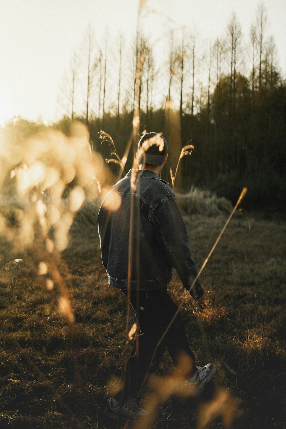 a man walking through a grass covered field