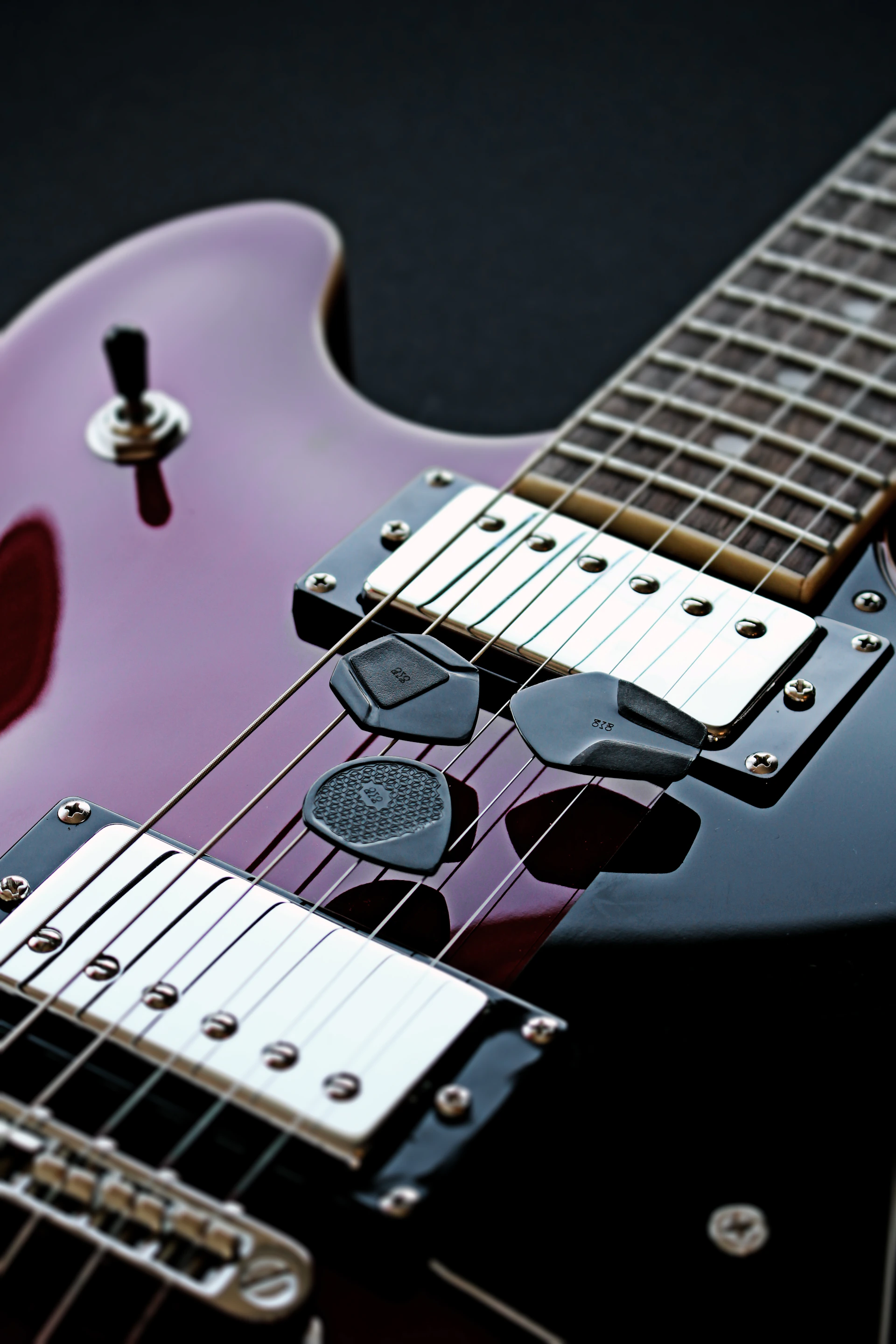 a close up of an electric guitar with a purple body