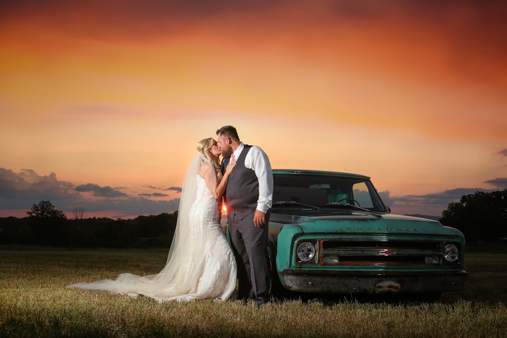 a bride and groom standing in front of a truck