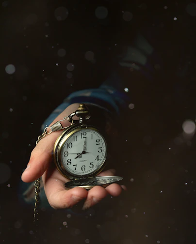 a person holding a clock in their hand