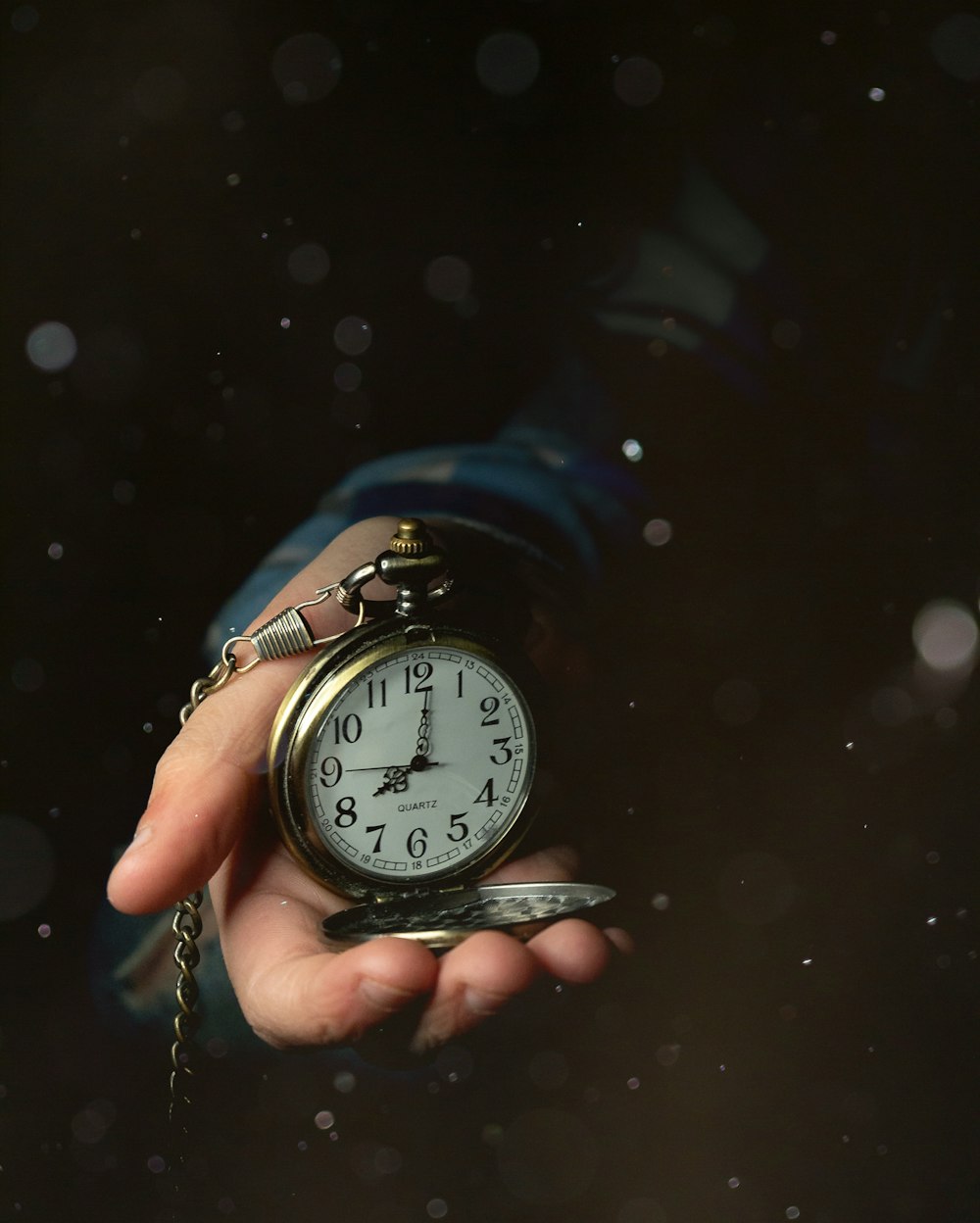 a person holding a clock in their hand