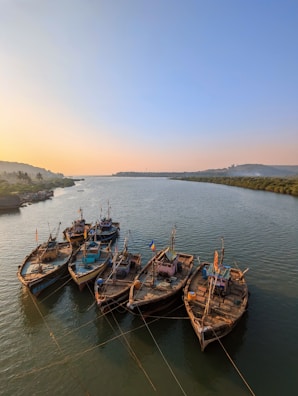 A serene river scene with fishermen in wooden boats at sunrise.
