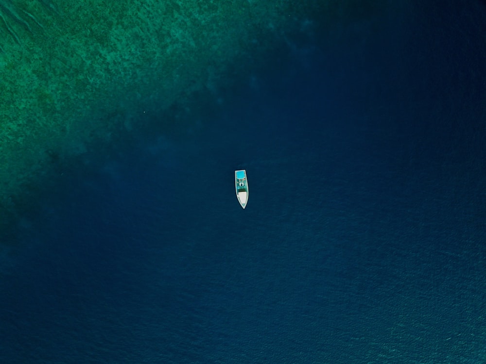 an aerial view of a boat in the ocean