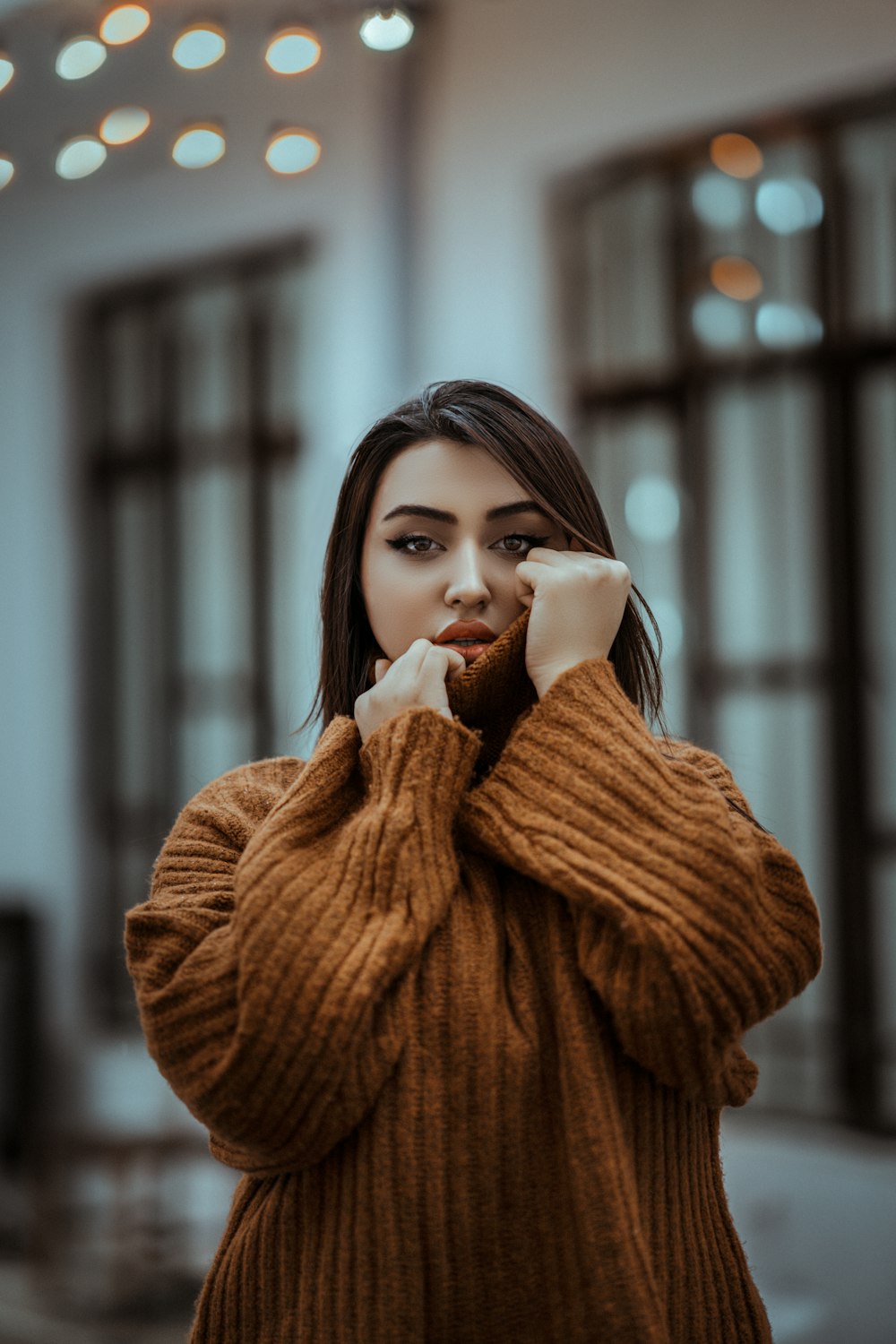 a woman in a brown sweater posing for a picture
