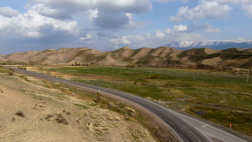 a road in the middle of a desert with mountains in the background