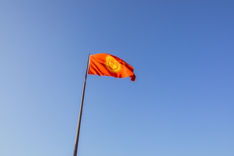 a red flag flying in the wind on a clear day