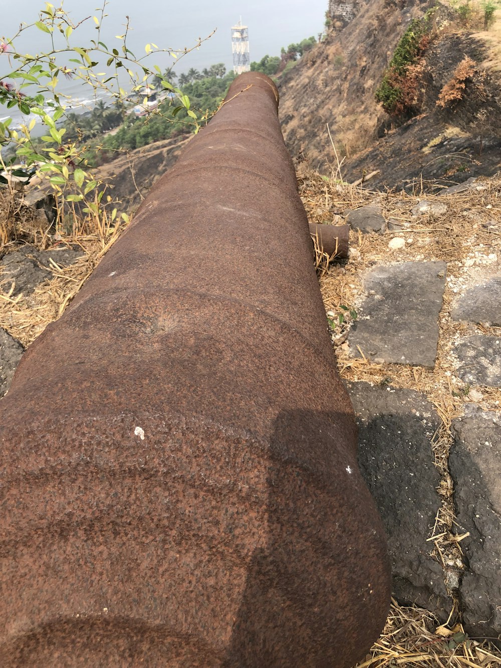 a large pipe laying on top of a rocky hillside
