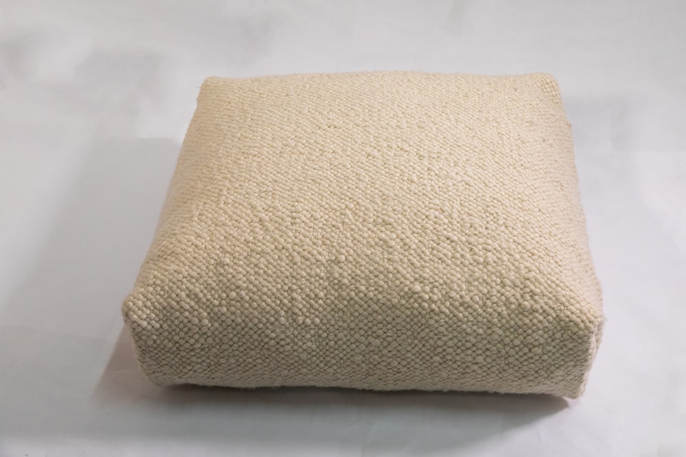 a close up of a pillow on a white surface