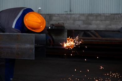 a man wearing a hard hat working on a piece of metal