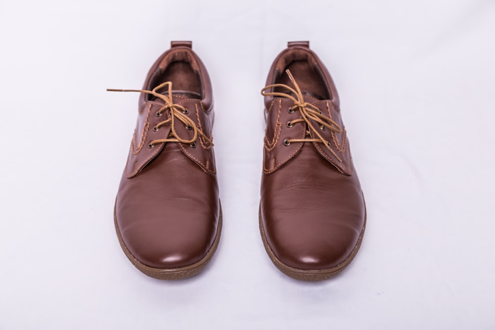 a pair of brown shoes on a white background