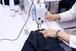 a woman using a sewing machine to sew clothes