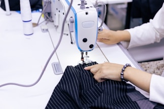 a woman using a sewing machine to sew clothes