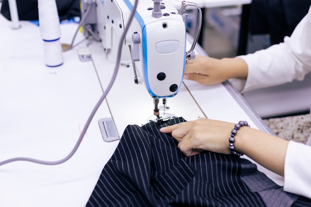 a woman using a sewing machine to sew clothes