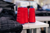 two red spools of thread sitting on a table