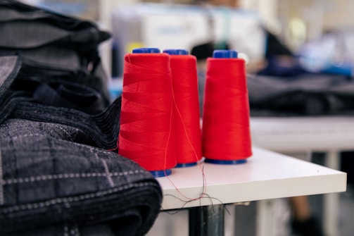 two red spools of thread sitting on a table