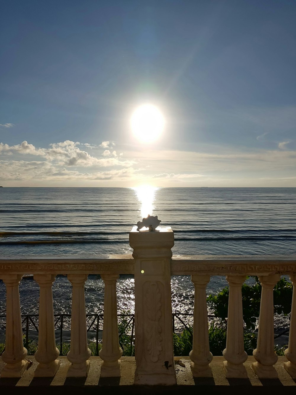 the sun is shining over the ocean from a balcony