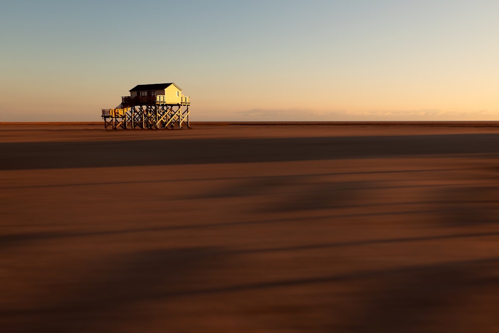 a house on stilts in the middle of the desert