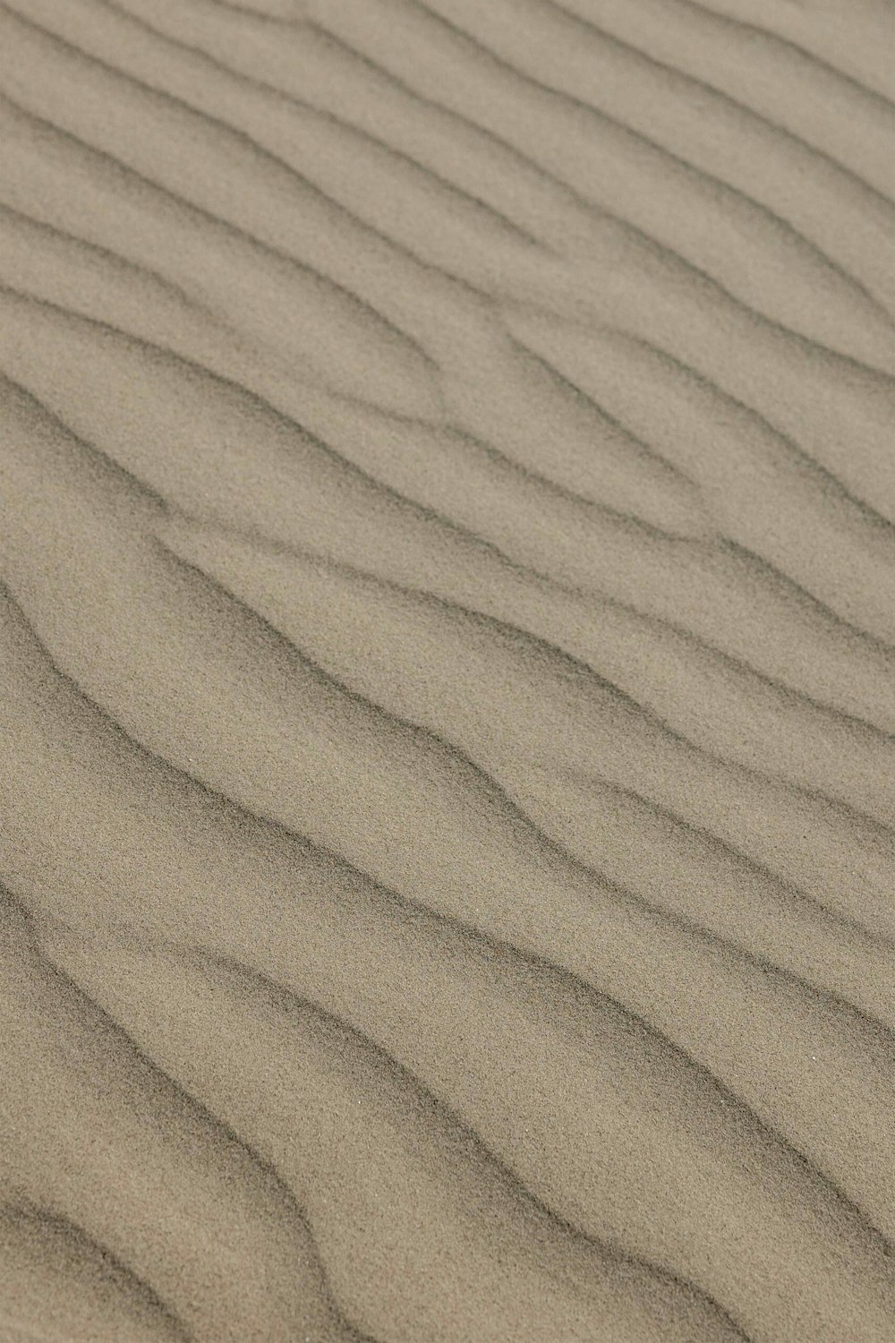 a sand dune with wavy lines in the sand