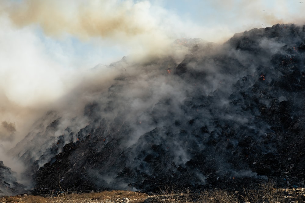 smoke billowing out of the top of a mountain