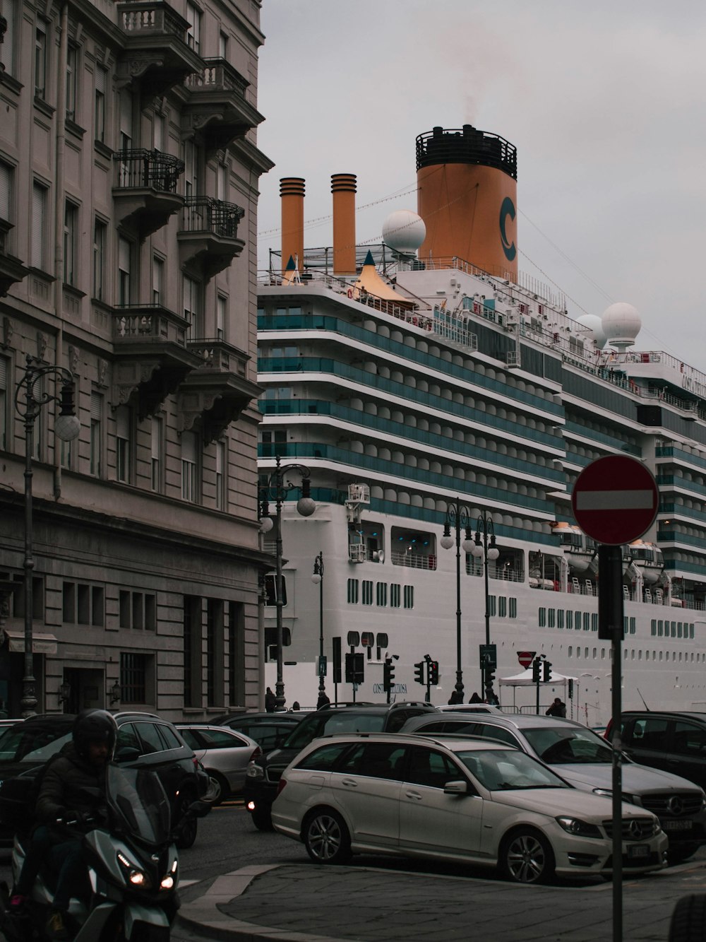 Un bateau de croisière en arrière-plan avec des voitures garées devant lui