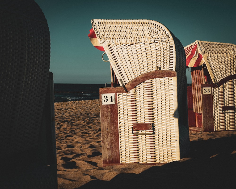 a couple of chairs sitting on top of a sandy beach