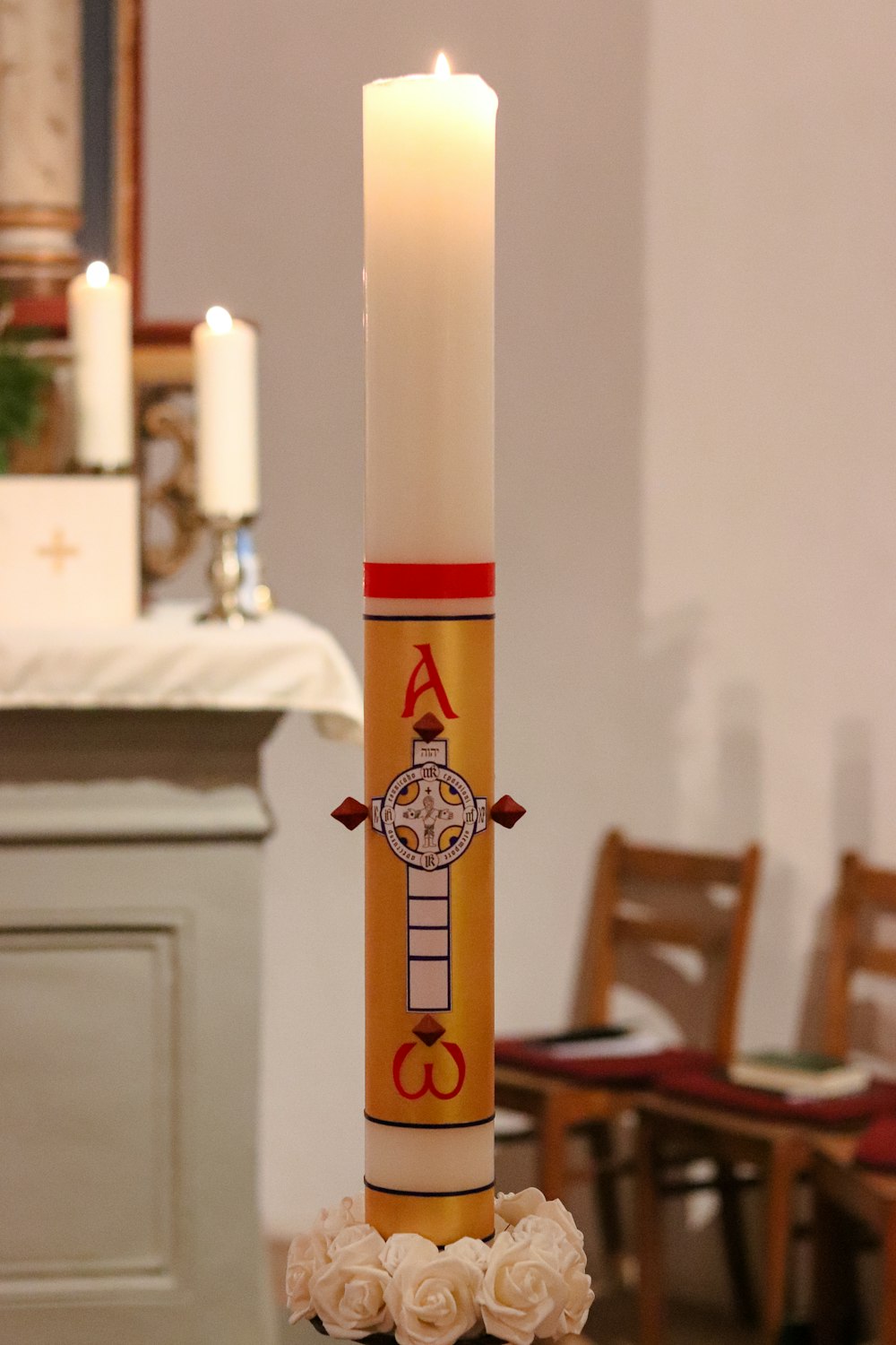 a tall candle with a cross on top of it