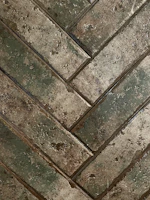 Rustic stone tiles arranged in a herringbone pattern with natural textures.