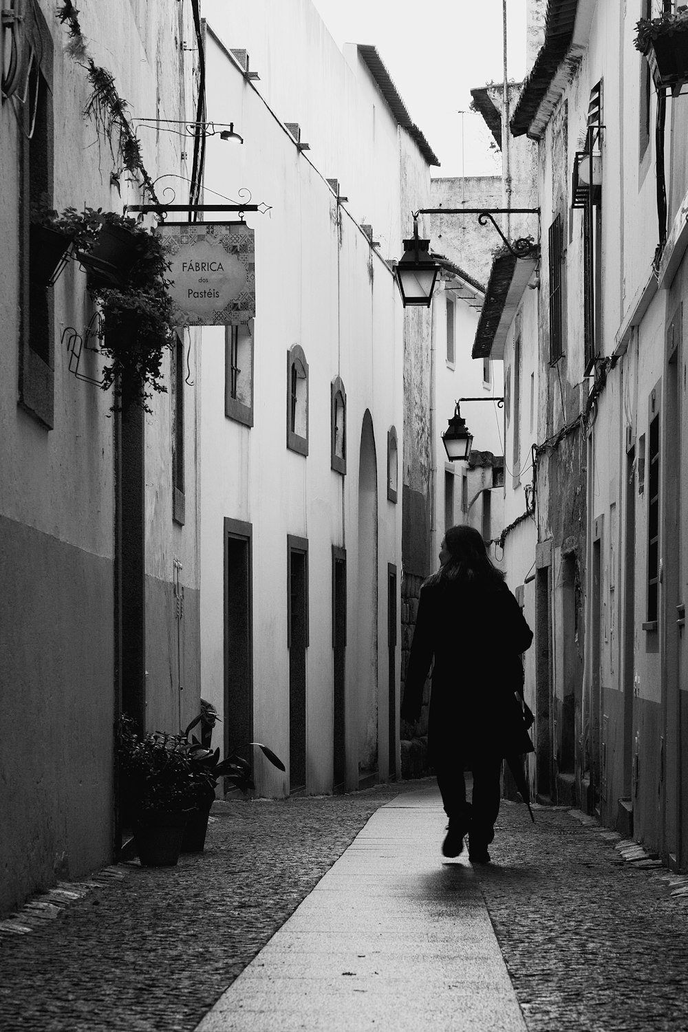 a black and white photo of a person walking down a street