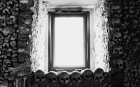 a black and white photo of a window in a stone wall