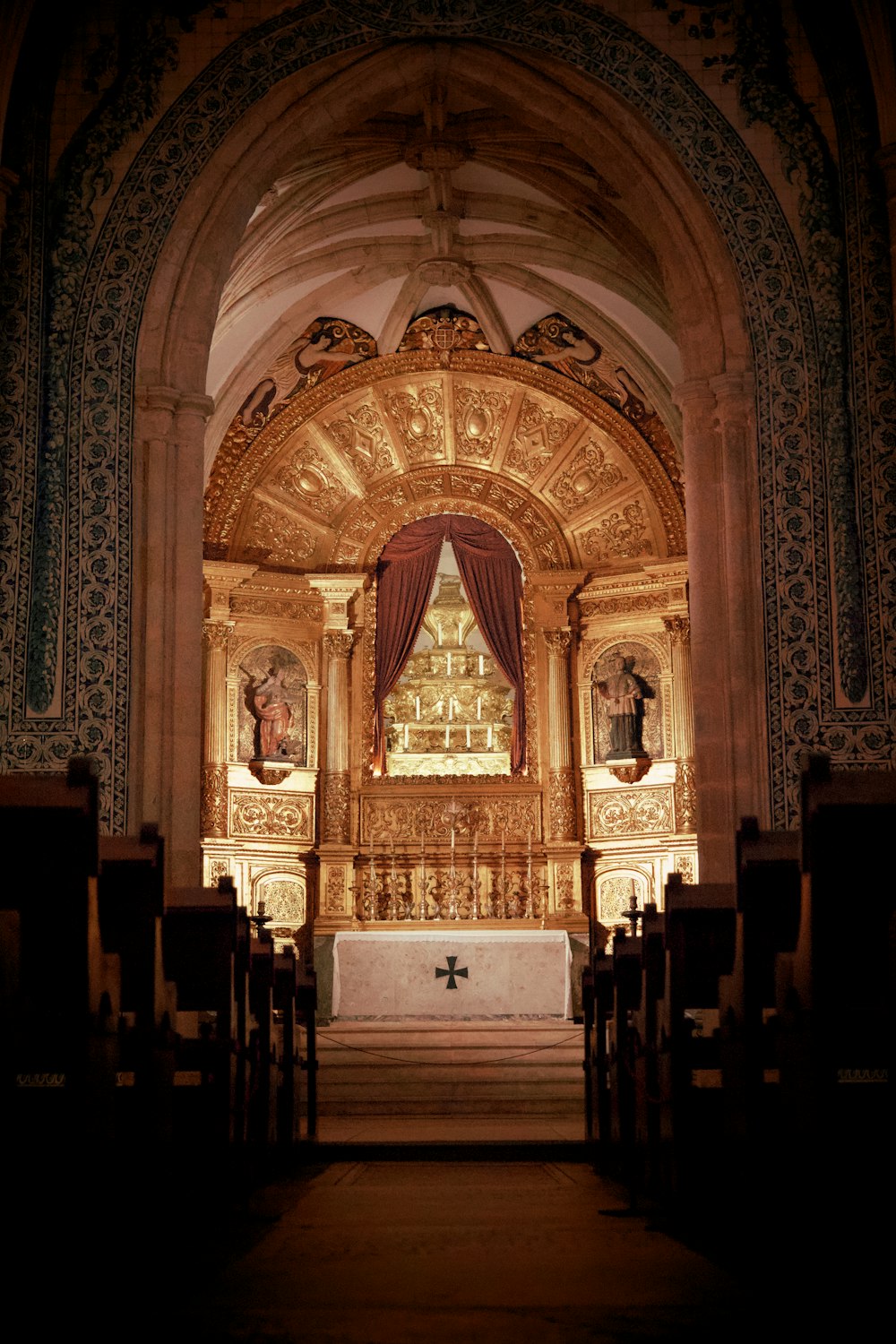 a church with a gold alter and red curtains