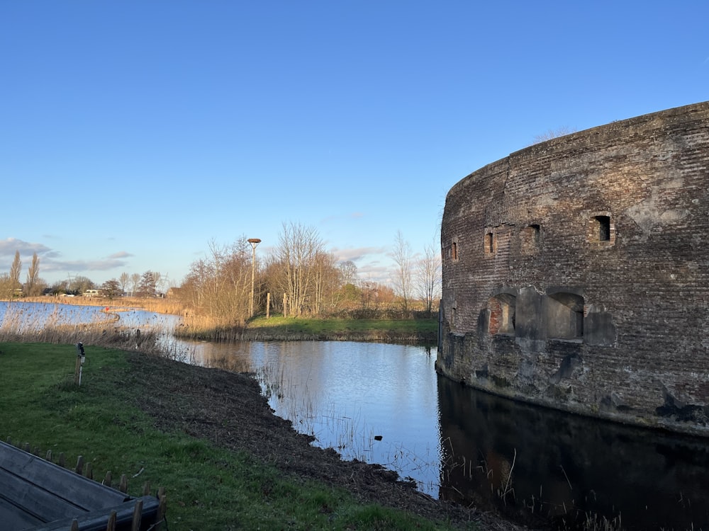 a large brick wall next to a body of water