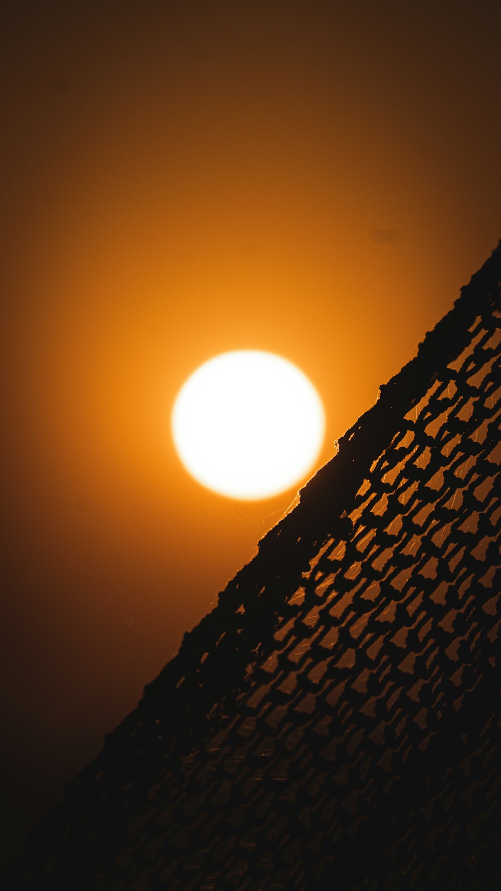 the sun is setting behind a hammock