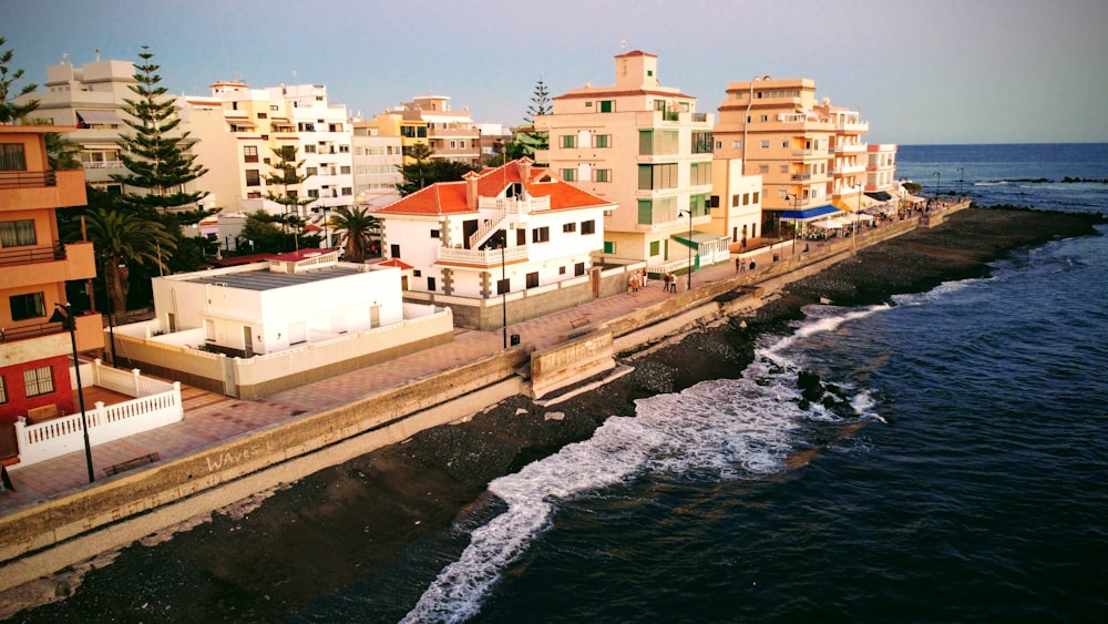 a view of a beach and a row of buildings next to the ocean