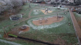 Wide shot of a playground maintenance team inspecting playground safety and equipment.