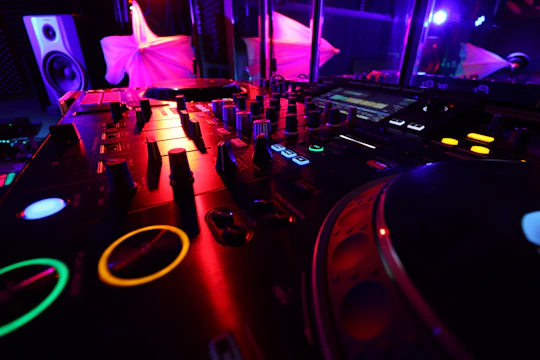 A sleek DJ setup featuring Pioneer DJ equipment with colorful lighting in a modern studio.