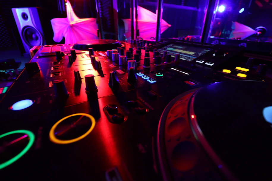 Close-up of DJ Kelblizz mixing tracks in a sleek studio surrounded by high-tech equipment