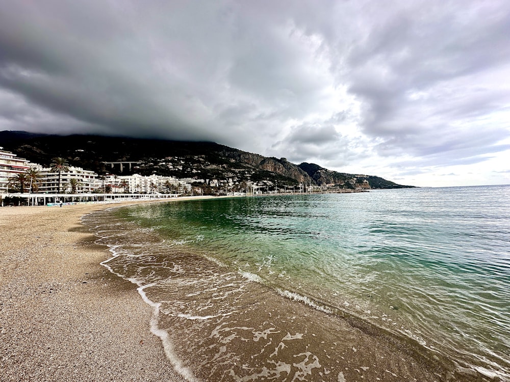 a sandy beach with waves coming in to shore