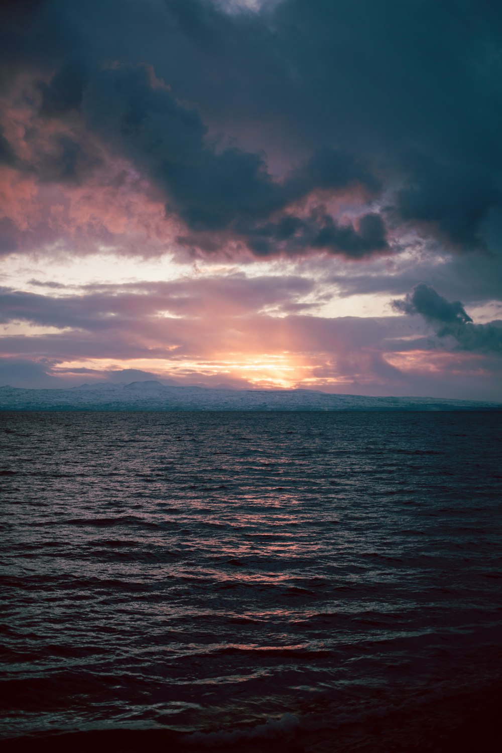 a large body of water under a cloudy sky