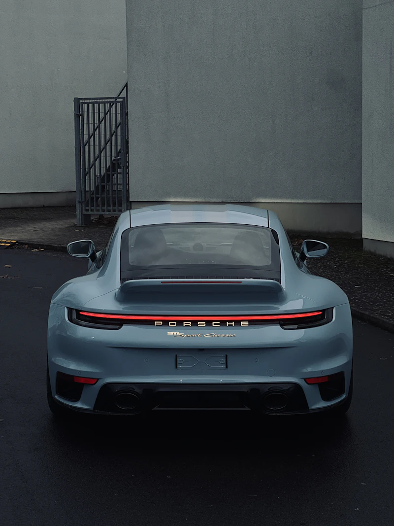 Grey sports car parked in front of a building