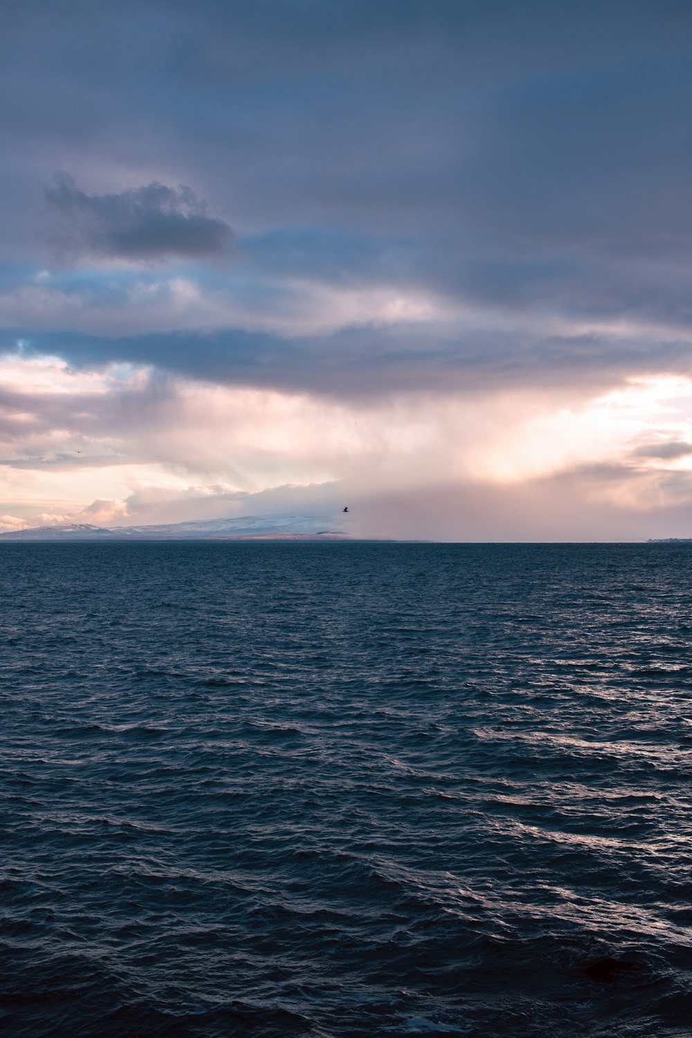 a large body of water under a cloudy sky