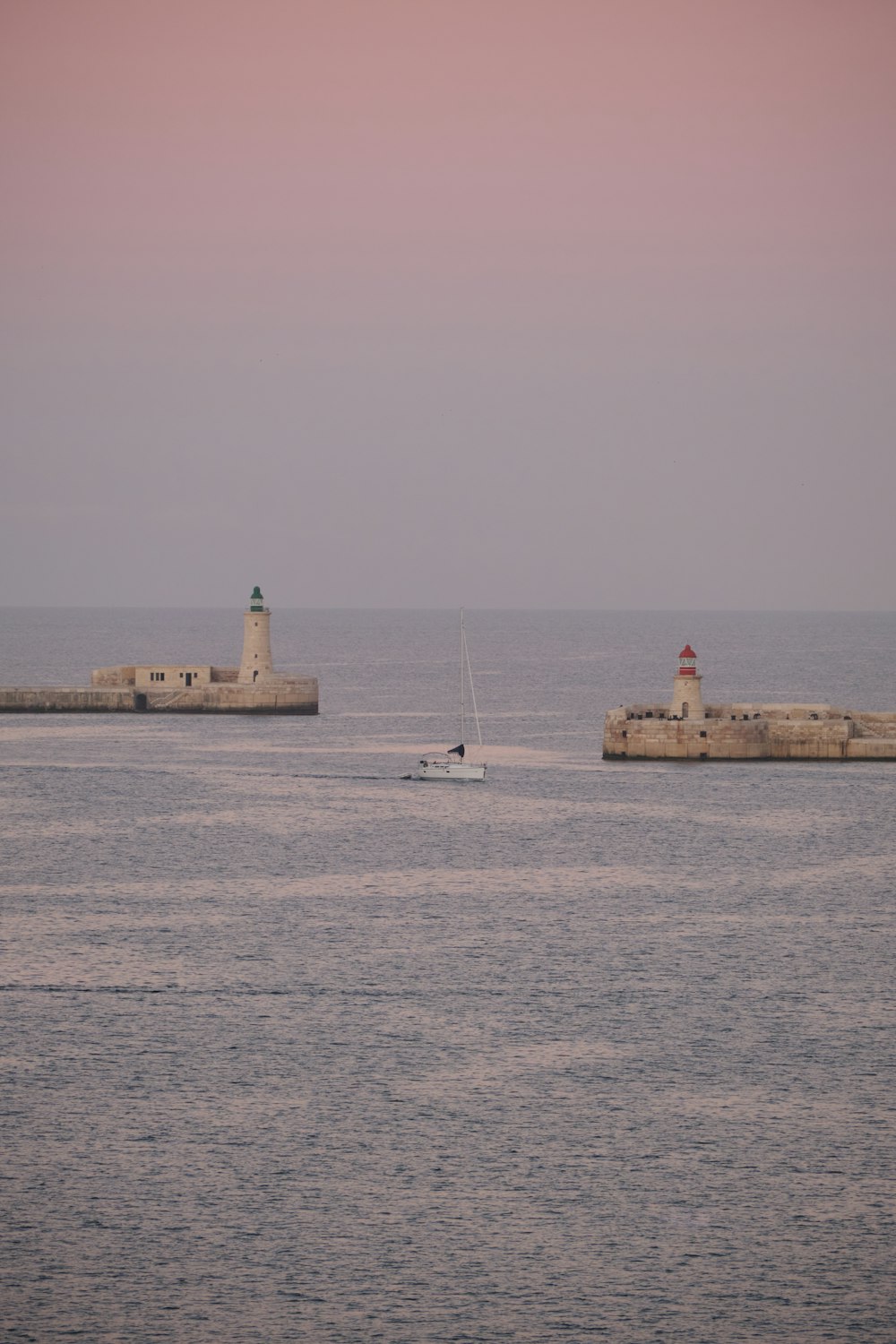 a small boat in the water near a light house