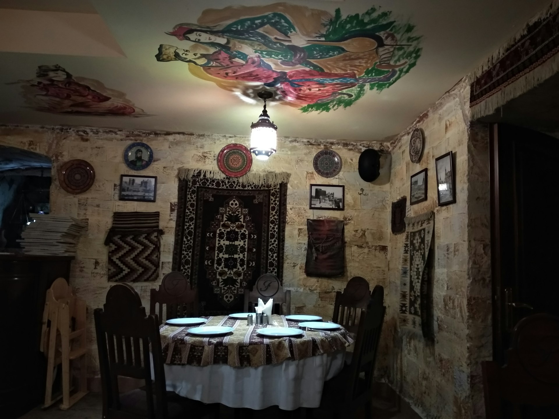 A cozy dining area featuring a rustic wooden table set for a meal with elegant tableware and soft lighting.