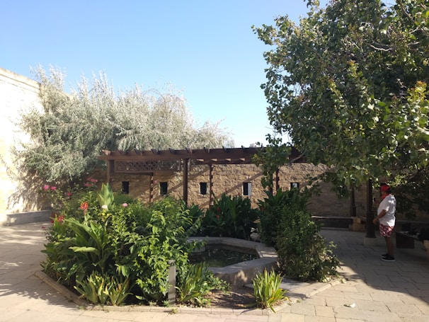 A serene outdoor garden where an adult client enjoys fresh air with a supportive staff member nearby.