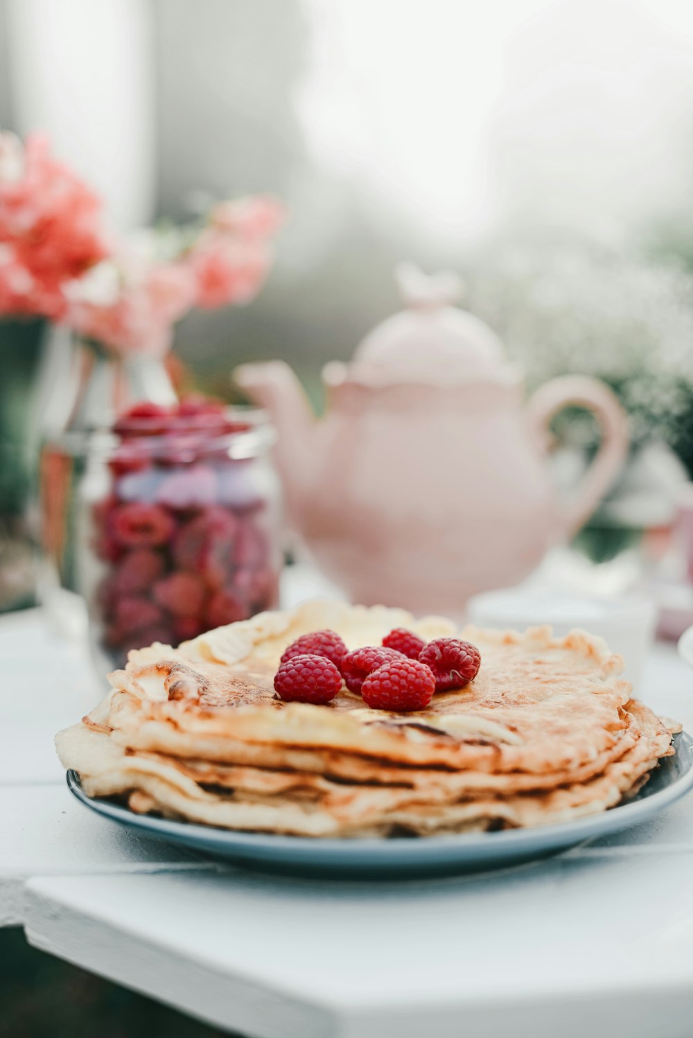 a stack of pancakes with raspberries on top of them