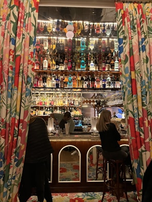 Fully stocked bar with bartenders preparing cocktails and members socializing.