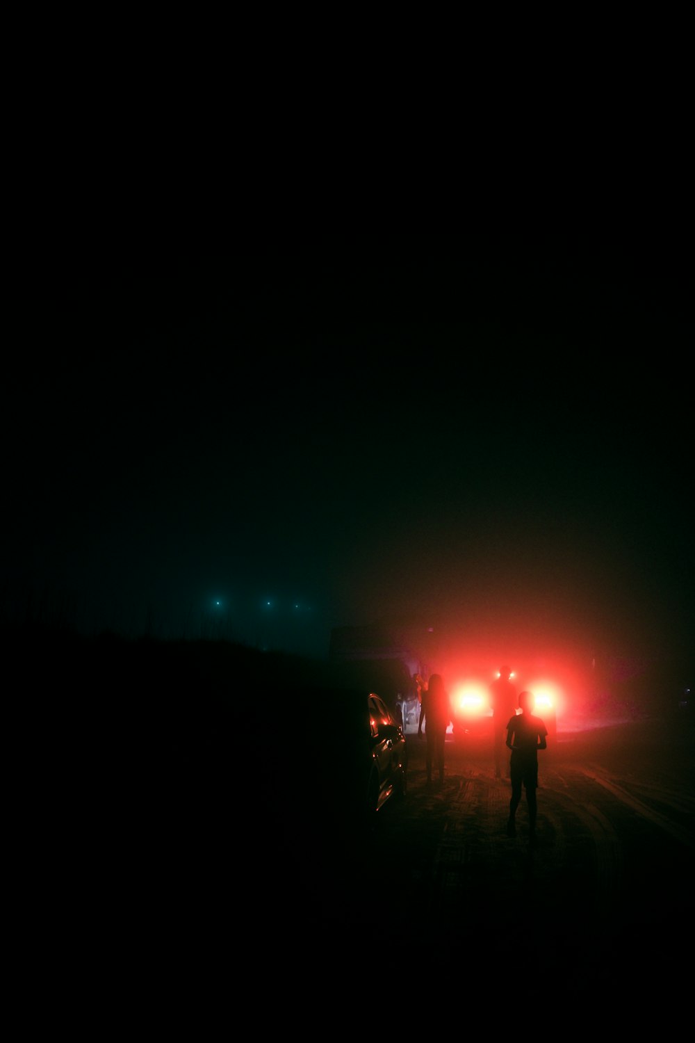 Un par de personas que están de pie en la oscuridad
