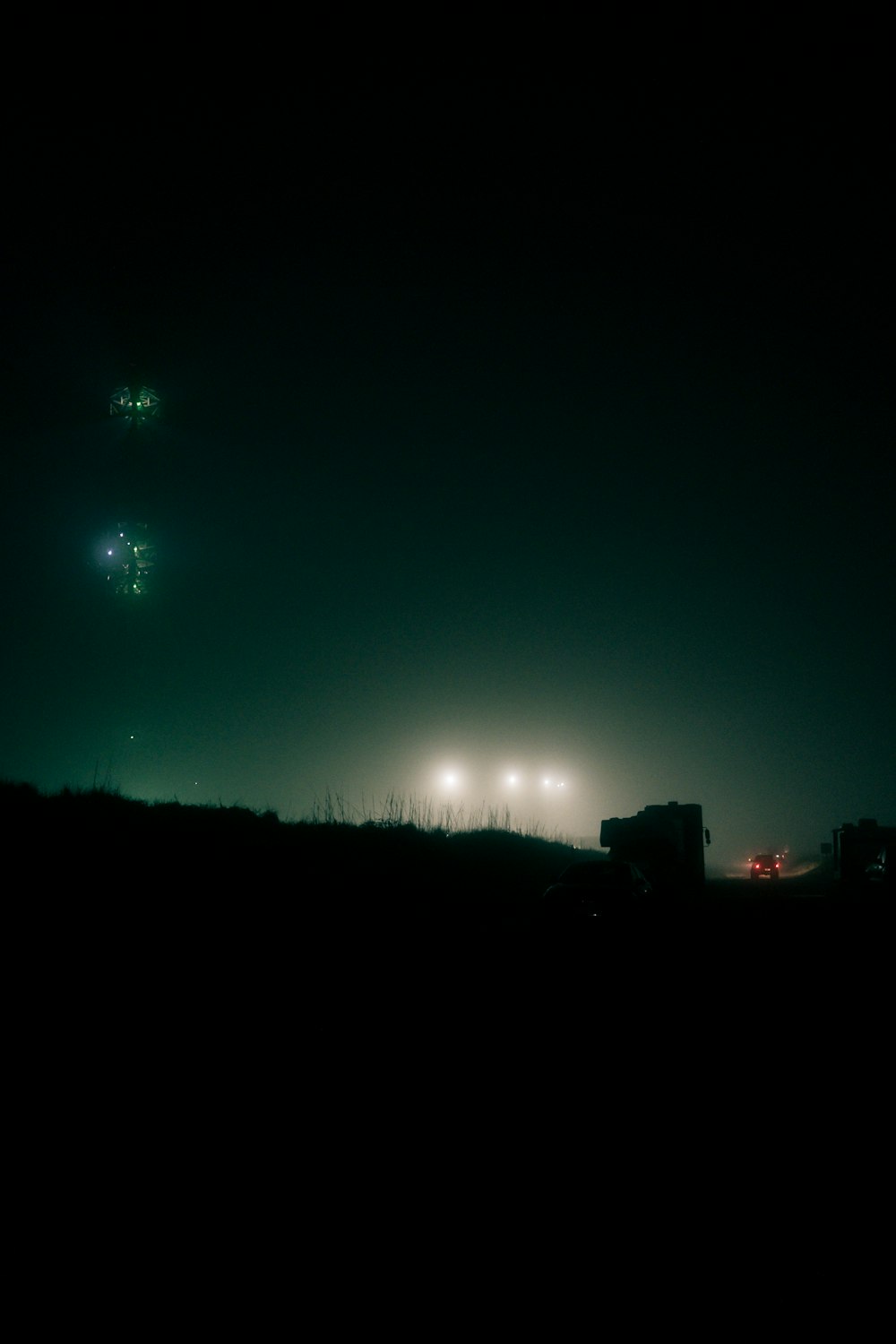 a couple of trucks driving down a road at night