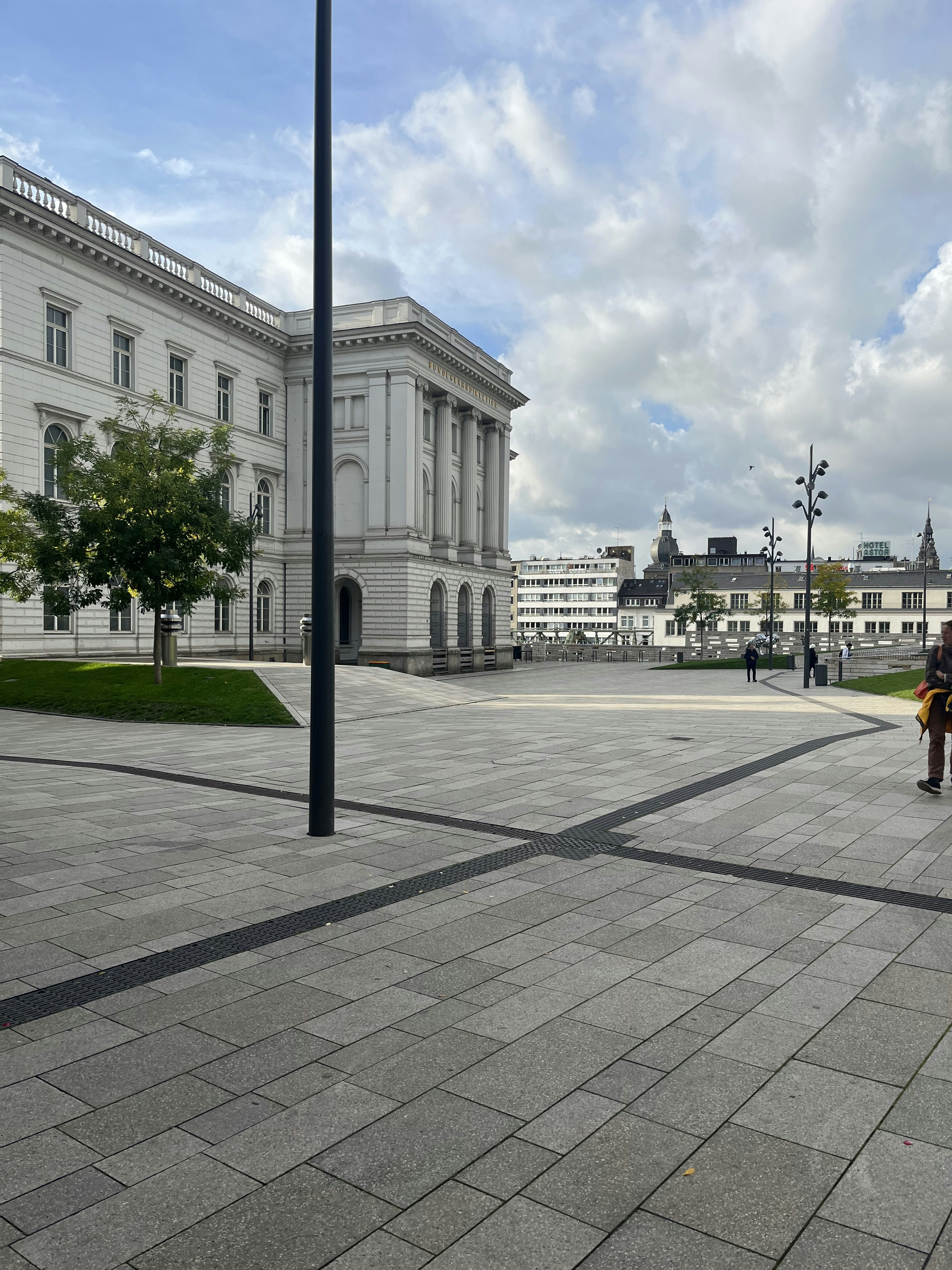 a person standing on a sidewalk in front of a building