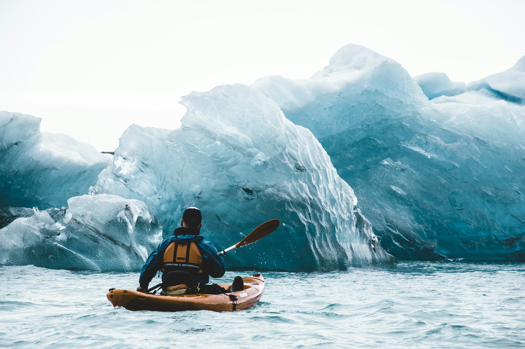 A guide kayaking through the glacial icebergs of Jökulsárlón, Iceland
