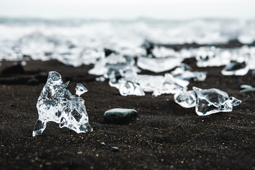 um grupo de pedaços de gelo sentados em cima de uma praia de areia preta